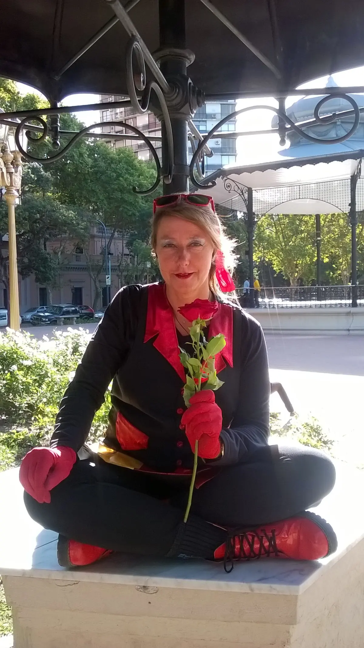 Carla Giúdice sentada al aire libre con un pañuelo rojo